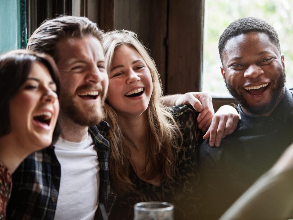 A group of friends in a pub posing for a picture.