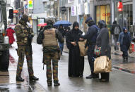 Belgian soldiers and a police officer control the documents of a woman in a shopping street in central Brussels, November 21, 2015. REUTERS/Youssef Boudlal