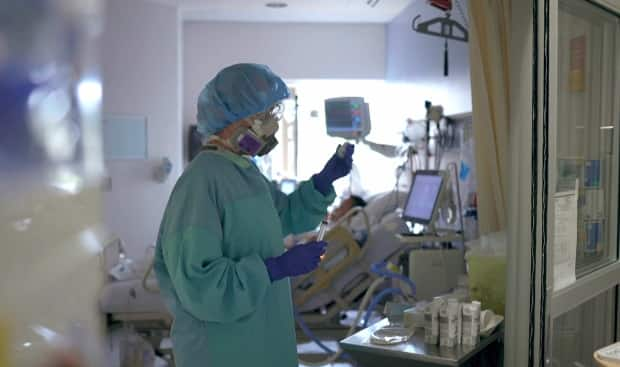 A nurse treats a patient inside the COVID-19 critical care unit at Vancouver General Hospital. (Vancouver Coastal Health - image credit)