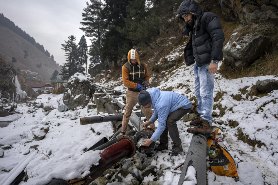 Government employees remove ice from water pipes as they work to restore water supply in Drang village northwest of Srinagar, Indian controlled Kashmir Friday, Dec. 22, 2023. In winter, water supply pipes often freeze in many areas of the upper reaches of Kashmir due to extreme cold wave conditions. Winter also affects daily routines in agriculture, transportation and other livelihoods. (AP Photo/Dar Yasin)