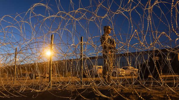 PHOTO: EL PASO, TEXAS - MAY 11: A Texas National Guard soldier stands vigil at a makeshift migrant camp near the U.S.-Mexico border fence on May 11, 2023 in El Paso, Texas. (John Moore/Getty Images)