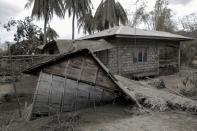 A hut damaged by Taal Volcano's eruption is covered with volcanic ash in Laurel