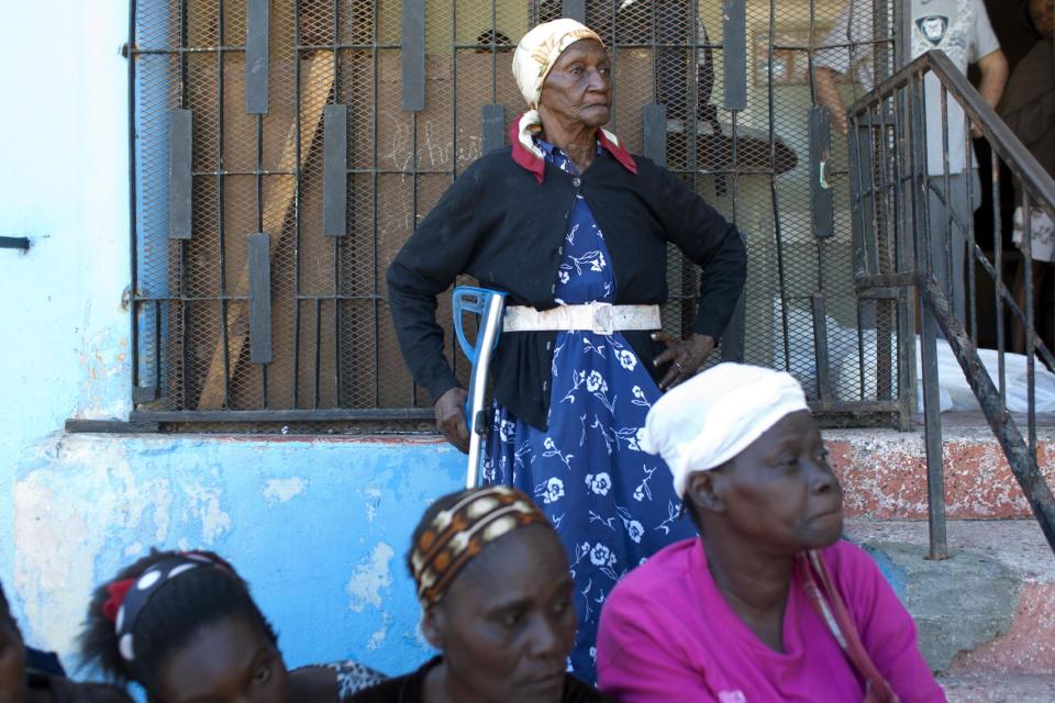 In this Feb. 1, 2014 photo, residents of Kenscoff wait for a free food distribution at the orphanage run by the U.S. Church of Bible Understanding in Kenscoff, Haiti. The Church of Bible Understanding, based in Scranton, Pennsylvania, is an evangelical group that emerged in the 1970's and previously known as the Forever Family. (AP Photo/Dieu Nalio Chery)