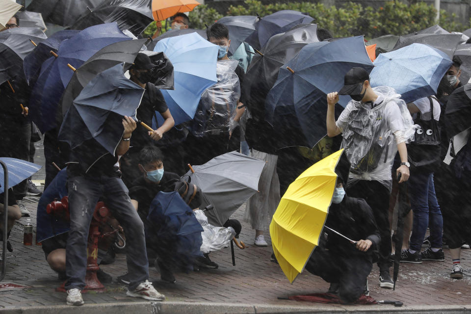 Protesters brace themselves against the strong wind and heavy rain as they gather outside the Eastern Court in Hong Kong, Wednesday, July 31, 2019. Charges were read Wednesday against more than 20 Hong Kong protesters who have been accused of rioting - the most serious charge brought since mass demonstrations began in the city last month. (AP Photo/Vincent Yu)