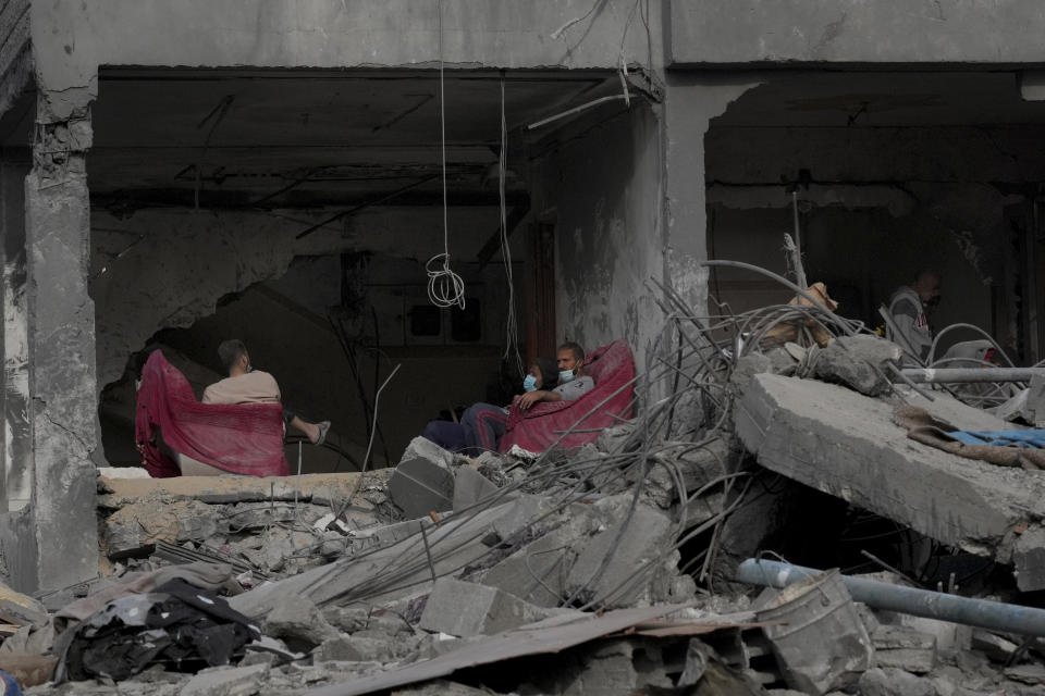 Palestinians sit in their home destroyed in the Israeli bombardment of Al Zawayda, central Gaza Strip, on Sunday, Dec. 10, 2023. (AP Photo/Hatem Moussa)