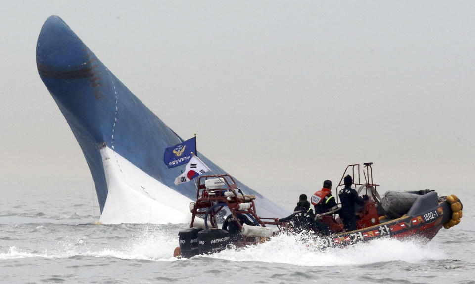 FILE - In this April 16, 2014 file photo, South Korean coast guard officers try to rescue passengers from the Sewol ferry as it sinks in the water off the southern coast near Jindo, south of Seoul, South Korea. It is a decision that has maritime experts stumped and is at odds with standard procedure: Why were the passengers of the doomed South Korean ferry told to stay in their rooms rather than climb on deck? Evacuations can be chaotic and dangerous, and an important principle in maritime circles is that even a damaged ship may be the best lifeboat. But car ferries like the Sewol, which left some 300 people missing or dead when it sank Wednesday, are different. They are particularly susceptible to rapid capsizing which makes it critically important that the crew quickly evacuate passengers when there is trouble. (AP Photo/Yonhap, File) KOREA OUT