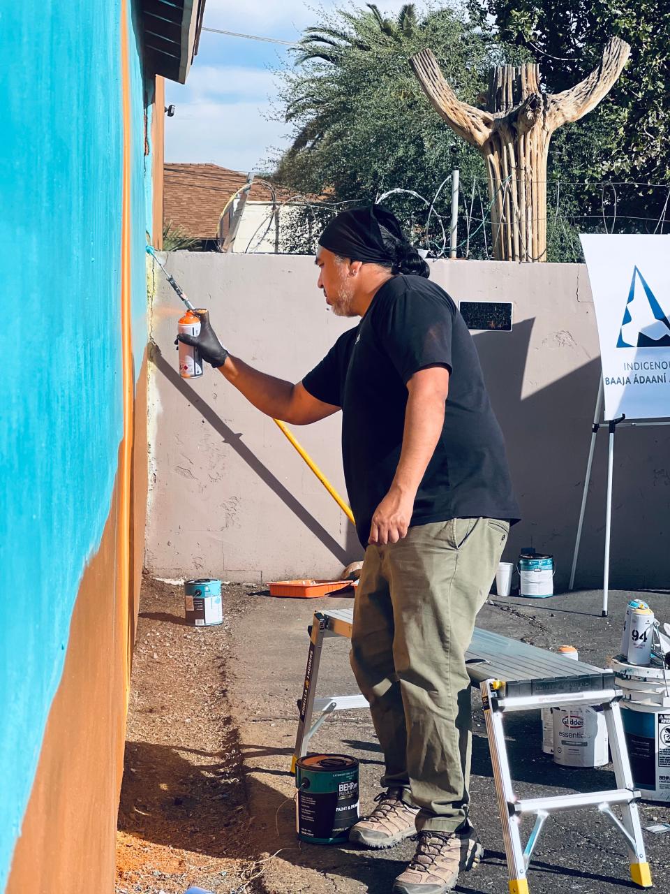 Muralist Thomas “Breeze” Marcus works on a mural he hopes will drive home the importance of Native voting power.