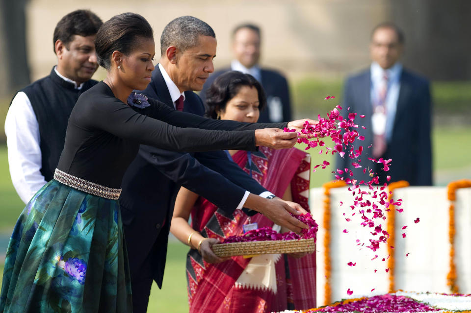 U.S. President Barack Obama and First Lady Michelle Obama spread rose petals as they participate in a wreath laying ceremony at Raj Ghat in New Delhi, India, Nov. 8, 2010. | Jim Watson–AFP/Getty Images