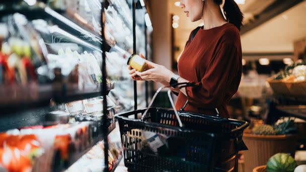 PHOTO: A woman shopping for groceries examines a food label while holding a shopping basket in an undated stock image. (STOCK PHOTO/D3sign/Getty Images)