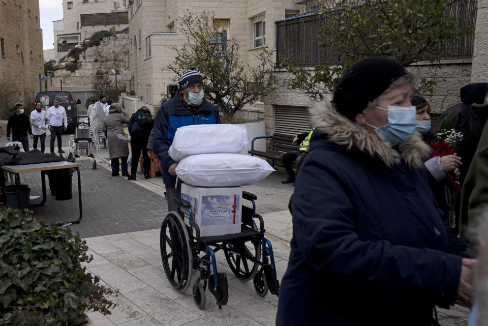 Several dozen impoverished elderly Israelis, many of them Holocaust survivors, gather for distribution of food aid and cold weather supplies by the Chasdei Naomi charity, ahead of International Holocaust Remembrance Day in Jerusalem, Wednesday, Jan. 26, 2022. Thursday marks the 77th anniversary of the liberation of the Nazi’s Auschwitz-Birkenau death camp in Poland. (AP Photo/Maya Alleruzzo)