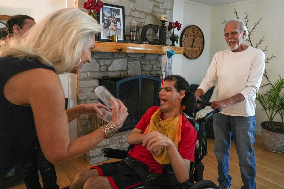 Phyllis Campos, left and René Campos, right, play with son Cody Campos. The 28-year-old, who has had cerebral palsy since birth, has been taken off hospice care and will move onto palliative care.
