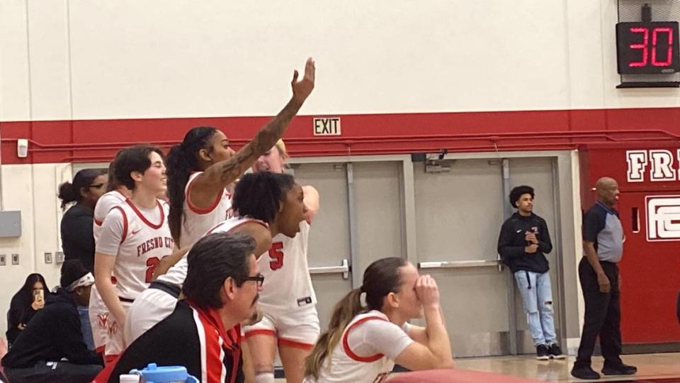 The Fresno City College women’s basketball team cheer on teammates.