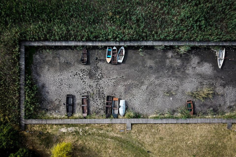 Boats lay on the dried lake bed in a port in Velence, Hungary last week (AP)