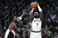 Boston Celtics guard Jaylen Brown (7) takes a shot over Portland Trail Blazers center Deandre Ayton, left, during the first half of an NBA basketball game, Sunday, April 7, 2024, in Boston. (AP Photo/Charles Krupa)