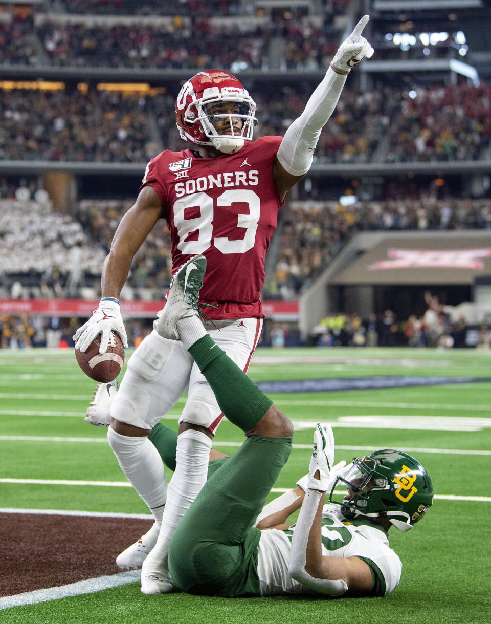 Oklahoma wide receiver Nick Basquine (83) celebrates a touchdown reception over Baylor safety JT Woods (22) during the second half of an NCAA college football game for the Big 12 Conference championship, Saturday, Dec. 7, 2019, in Arlington, Texas. Oklahoma won 30-23 in overtime. (AP Photo/Jeffrey McWhorter)