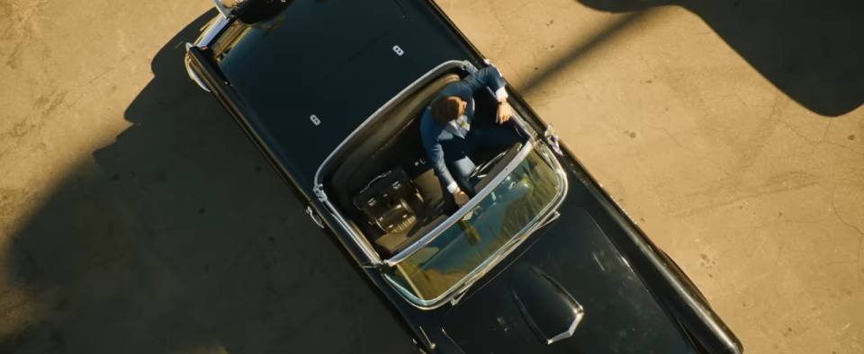 An overhead view of a man sitting in his vintage car