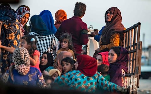 Civilians flee amid Turkish bombardment on Syria's northeastern town of Ras al-Ain in the Hasakeh province along the Turkish border  - Credit: AFP