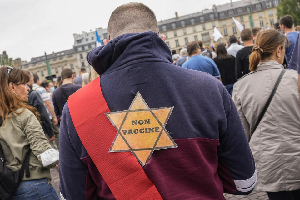 A star that reads, not vaccinated is attached on the back of an Anti-vaccine protesters during a rally in Paris, Saturday, July 17, 2021. A Holocaust survivor, French officials and anti-racism groups are denouncing anti-vaccination protesters who are comparing themselves to Jews persecuted by the Nazis. Some mostly far-right demonstrators at weekend protests against government vaccine rules wore yellow stars, like those Jews were forced to wear under Nazi rule in World War II. Other demonstrators carried signs evoking the Auschwitz death camp or South Africa's apartheid regime, claiming the French government is unfairly persecuting them as it battles the pandemic. (AP Photo/Michel Euler, File)