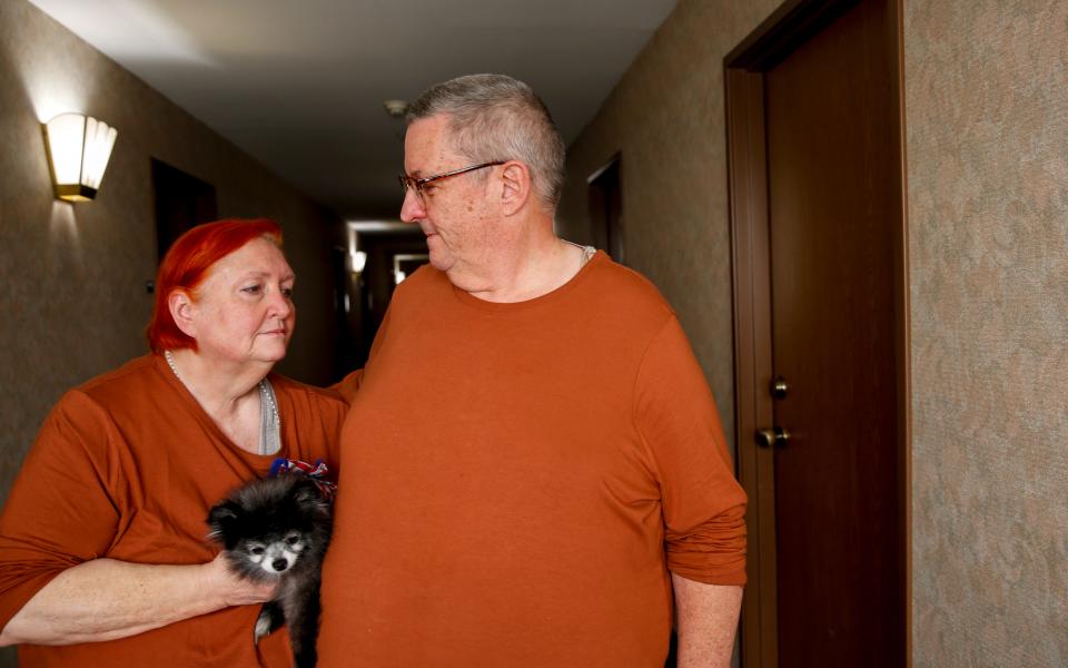 Dennis and Denise Schlies pose for a portrait with their dog Guni, on Tuesday, Sept. 15, 2020 at a hotel in Salem, Oregon. Dennis Schlies is a 911 dispatcher known by many as the "Voice of the Canyon." Schlies was taking calls the night the wildfires exploded, all while his very own home in Gates, Oregon was burning down. 