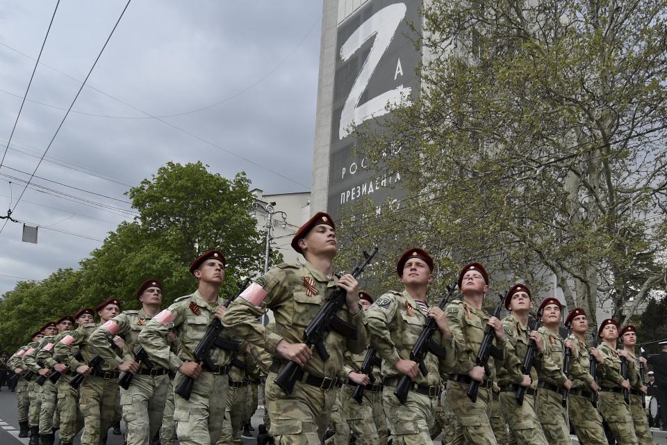 Russian National Guard (Rosguardia) servicemen march through a street with a letter Z, which has become a symbol of the Russian military on a building in Sevastopol, Crimea, Thursday, May 5, 2022. (AP Photo)