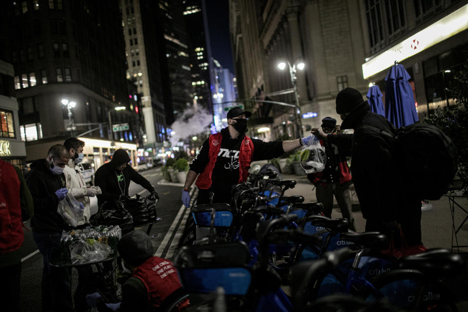 Mohammed Widdi, 31, center, a volunteer with Muslims Giving Back, hands out food donations to the needy in Herald Square, New York, on Friday, April 24, 2020. During the COVID-19 coronavirus outbreak, a group of Muslim volunteers are celebrating their holy month of Ramadan by putting their faith into action. (AP Photo/Wong Maye-E)