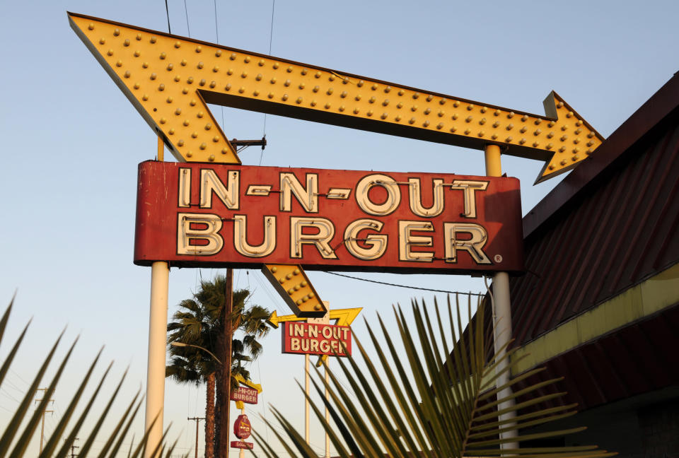 In-N-Out Burger signs from the fast food chain's original location, and one in the background at a new location across the Interstate 10 freeway, fill the skyline.