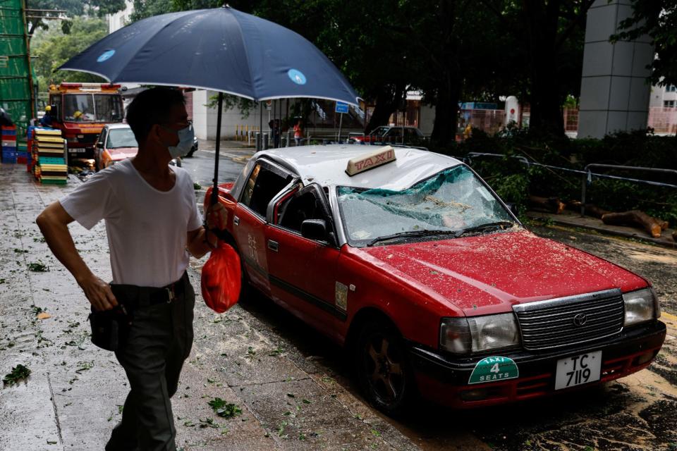 蘇拉颱風1日晚間夾著狂風暴雨侵襲香港。一輛停放路邊的計程車被倒塌路樹擊中車頂。路透社