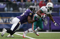 Running back Travis Minor #28 of the Miami Dolphins tries to shake Terrell Suggs #55 of the Baltimore Ravens as the Ravens defeated the Miami Dolphins 30-23 during NFL action at M&T Bank Stadium on January 2, 2005 in Baltimore, Maryland. (Photo by Doug Pensinger/Getty Images)