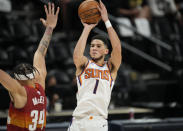 Phoenix Suns guard Devin Booker, right, shoots over Denver Nuggets center JaVale McGee in the first half of Game 4 of an NBA second-round playoff series Sunday, June 13, 2021, in Denver. (AP Photo/David Zalubowski)