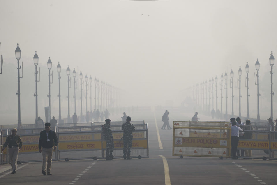 Security officers stand guard enveloped by smog early morning in New Delhi, India, Wednesday, Dec. 13, 2023. The city is witnessing an increase in the pollution level, which continued to stay within the very poor category. (AP Photo/Manish Swarup)