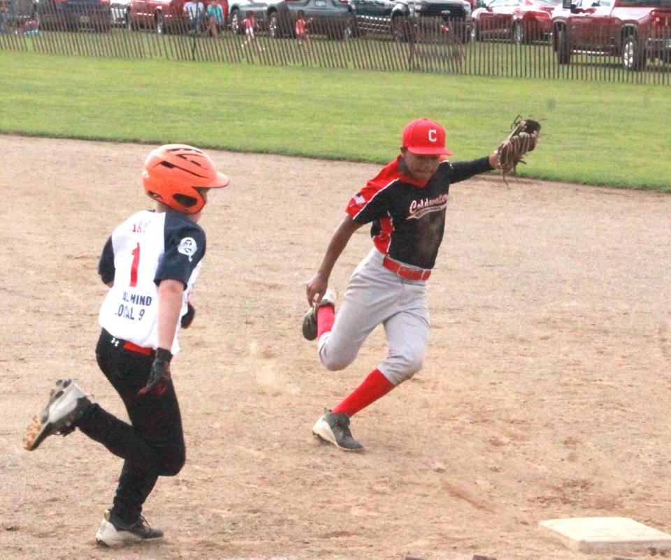 Coldwater's Royal Fleming tries to out race Quincy's Joe Gray to the bag in a close play at first base Tuesday. Gray was called safe on the play.