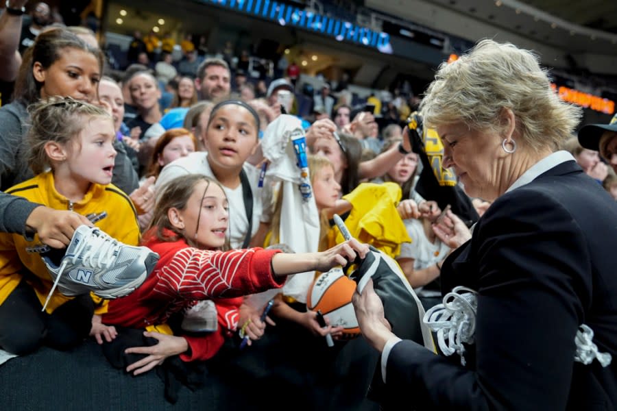 Iowa head coach Lisa Bluder signs autographs for fans after defeating LSU in an Elite Eight round college basketball game during the NCAA Tournament, Monday, April 1, 2024, in Albany, N.Y. (AP Photo/Mary Altaffer)