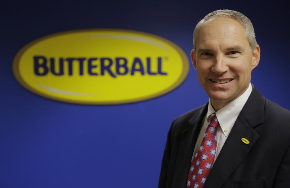 In this Nov. 22, 2013 photo Butterball Turkey CEO Rod Brenneman posies in front of a sign at a Turkey Talk-Line facility in Naperville, Ill. (AP Photo/M. Spencer Green)