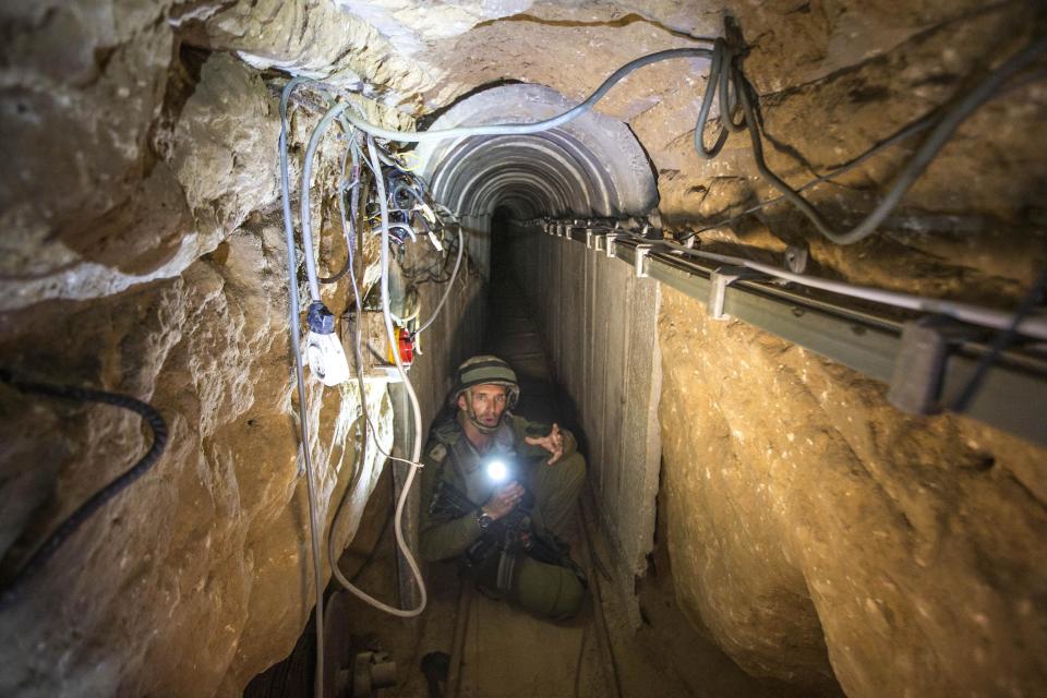 An Israeli army officer gives journalists a tour of a tunnel allegedly used by Palestinian militants for cross-border attacks, July 25, 2014. (AP/Jack Guez, Pool)