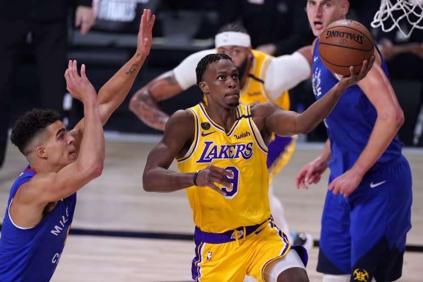 Los Angeles Lakers guard Rajon Rondo (9) goes up for a shot between Denver Nuggets' Michael Porter Jr., left, and Nikola Jokic, right rear, during the second half an NBA conference final playoff basketball game, Friday, Sept. 18, 2020, in Lake Buena Vista, Fla. (AP Photo/Mark J. Terrill)