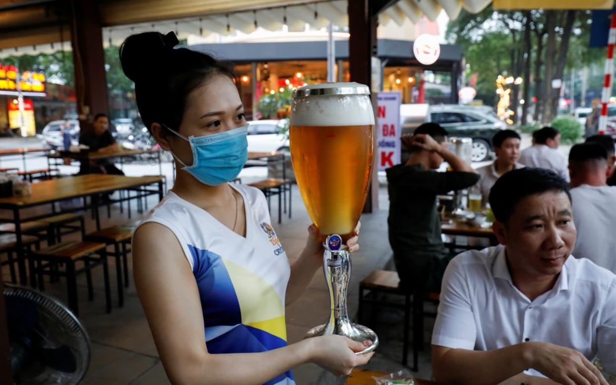 A woman serves beer at a restaurant in Hanoi after the government eased nationawide lockdown during the coronavirus disease - Reuters