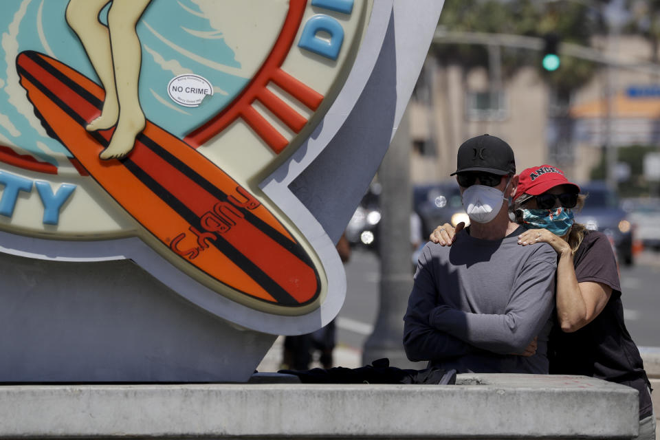 People watch during a May Day demonstration at the pier, Friday, May 1, 2020, in Huntington Beach, Calif. (AP Photo/Chris Carlson)