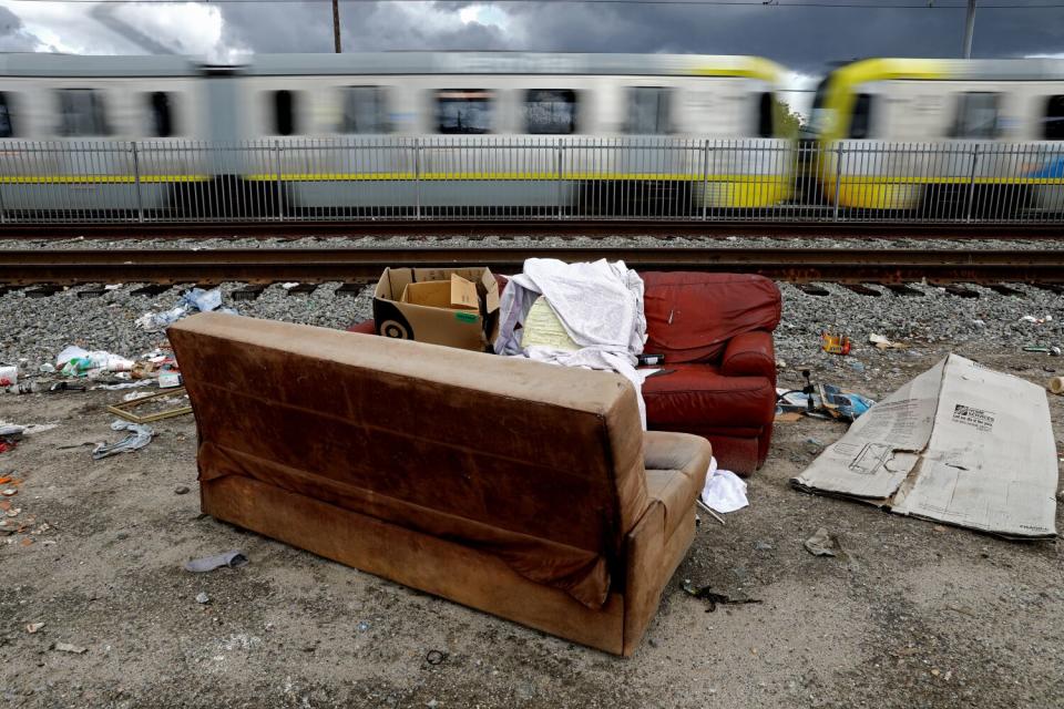 Furniture and trash discarded next to train tracks along Grandee Avenue in Watts.