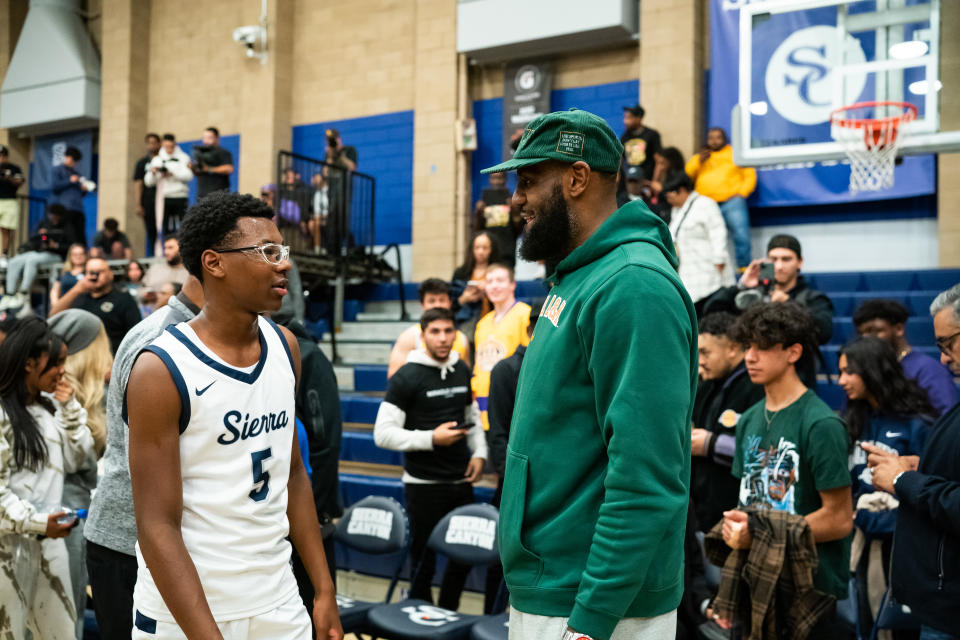 Bryce James talks to his dad, LeBron James, after a game last year. James had eight points (two 3-pointers) and three assists in a win on Saturday. (Photo by Cassy Athena/Getty Images)