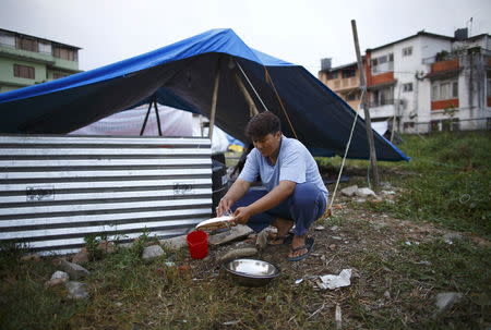 Laxmi Ghalan, 33, a lesbian, washes dishes outside a temporary makeshift shelter at a lesbian, gay, bisexual and transgender (LGBT) camp, a month after the April 25 earthquake in Kathmandu, Nepal May 29, 2015. REUTERS/Navesh Chitrakar