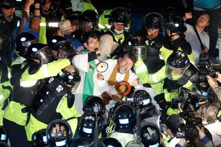 People scuffle with riot policemen during a protest opposing the deployment of a Terminal High Altitude Area Defense (THAAD) system in Seongju, South Korea, September 7, 2017. Lee Sang-hak/Yonhap via REUTERS