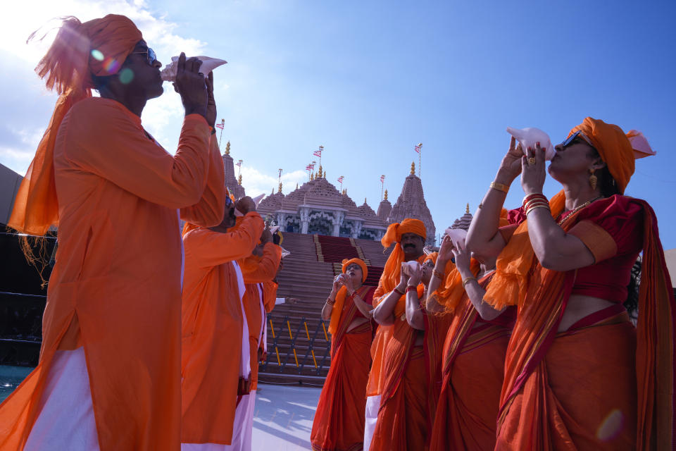 Devotees blow conch shells before the opening of the first stone-built Hindu temple in the Middle East, in Abu Mureikha, 40 kilometers (25 miles) northeast of Abu Dhabi, United Arab Emirates, Wednesday, Feb. 14, 2024. (AP Photo/Kamran Jebreili)