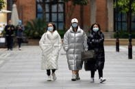 In this photo released by Xinhua News Agency, women wearing protective masks to prevent the new coronavirus outbreak walk on a re-opened commercial street in Wuhan in central China's Hubei province on Monday, March 30, 2020. Shopkeepers in the city at the center of China's virus outbreak were reopening Monday but customers were scarce after authorities lifted more of the anti-virus controls that kept tens of millions of people at home for two months. (Shen Bohan/Xinhua via AP)