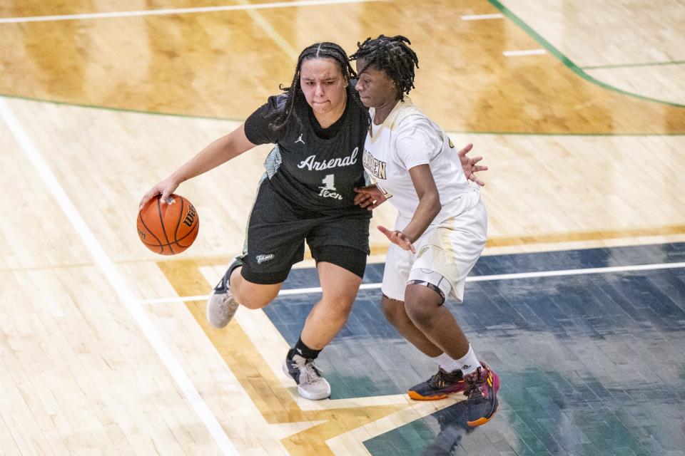 Indianapolis Arsenal Technical High School senior Kayla Lacombe (1) drives the ball into the defense of Warren Central High School senior Denyha Jacobs (10) during the second half of an IHSAA Class 4A Sectional semi-final basketball game, Friday, Feb. 2, 2024, at Cathedral High School.