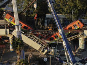 An aerial view of subway cars dangle at an angle from a collapsed elevated section of the metro, in Mexico City, Tuesday, May 4, 2021. The elevated section collapsed late Monday killing at least 23 people and injuring at least 79, city officials said. (AP Photo/Fernando Llano)