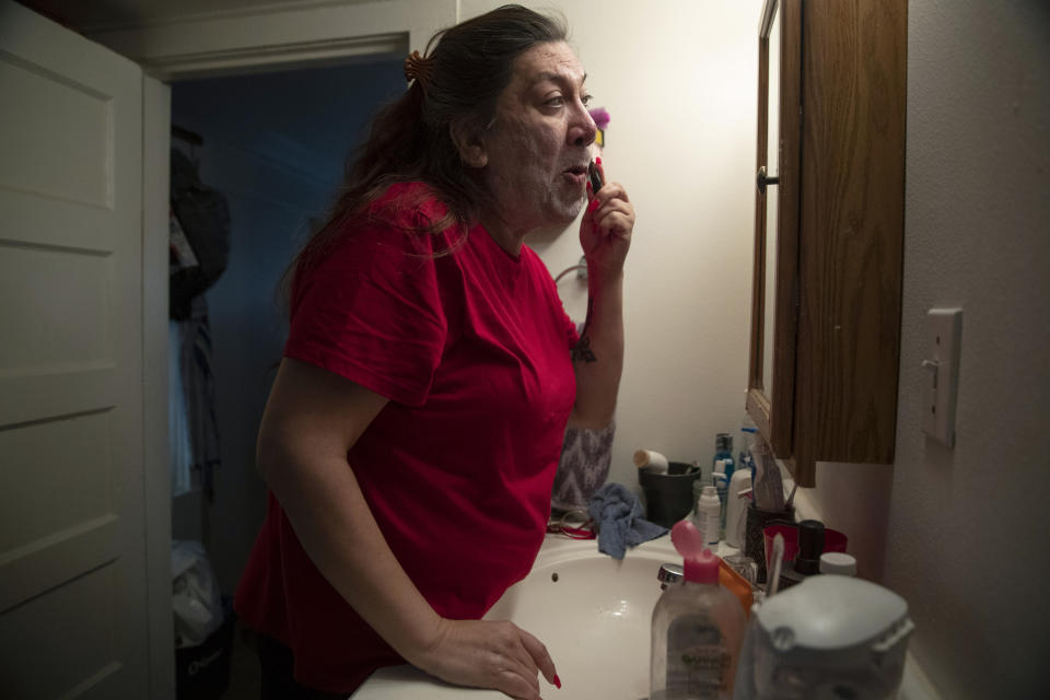 Christina Wood shaves before work in her home in Salem, Ore., Friday, April 21, 2023. Six years ago, Wood moved to Oregon, where she could access the gender-affirming health care she needed to live as her authentic self. Once there, Wood was able to receive certain surgeries that helped her transition, but electrolysis, or permanent hair removal, wasn’t fully covered under the state’s Medicaid plan for low-income residents. Democratic lawmakers in Oregon are advancing a bill that would expand insurance coverage for gender-affirming care to include things like facial hair removal and Adam’s apple reduction surgery. (AP Photo/Amanda Loman)