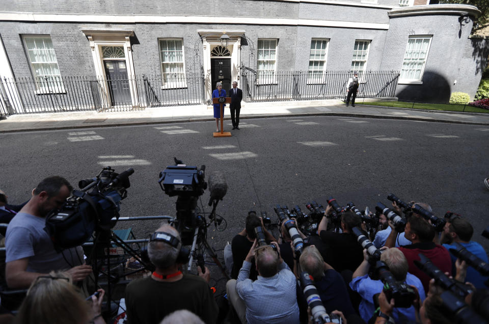 Britain's Prime Minister Theresa May is watched by her husband Philip as she speaks outside 10 Downing Street, London before leaving for Buckingham Palace where she will hand her resignation to Queen Elizabeth II, Wednesday, July 24, 2019. Boris Johnson will replace May as Prime Minister later Wednesday, following her resignation last month after Parliament repeatedly rejected the Brexit withdrawal agreement she struck with the European Union. (AP Photo/Frank Augstein)