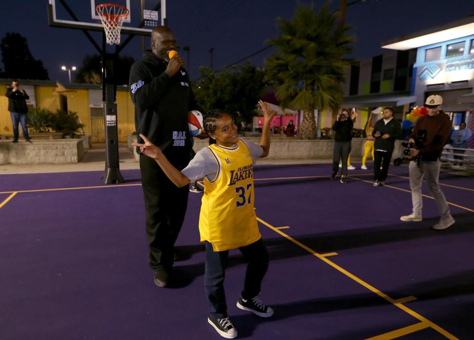 A fifth-grader celebrates next to Shaquille O'Neal after making a free throw.