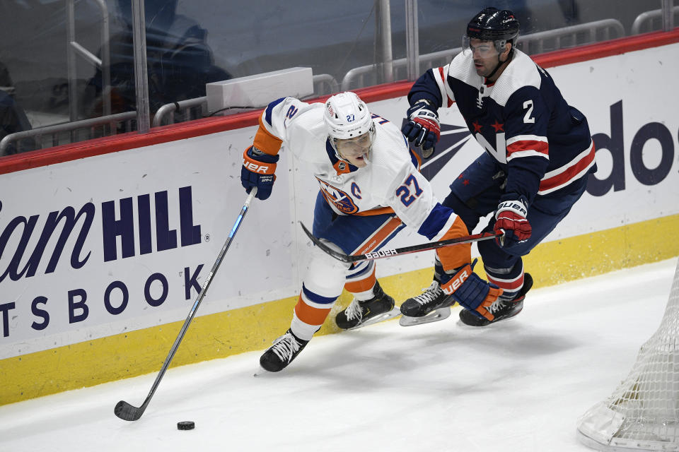 New York Islanders left wing Anders Lee (27) skates with the puck past Washington Capitals defenseman Justin Schultz (2) during the second period of an NHL hockey game Tuesday, Jan. 26, 2021, in Washington. (AP Photo/Nick Wass)