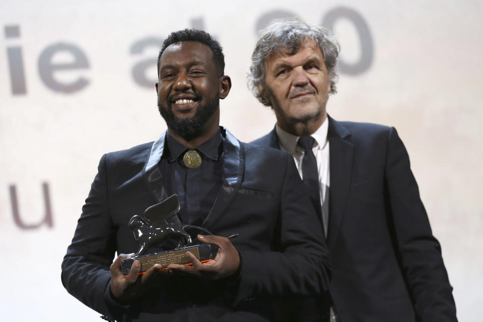 Director Amjad Abu Alala, left, holds the Luigi De Laurentiis Venice Award for a Debut Film for the film 'You Will Die At 20', presented by jury member Emir Kustirica at the closing ceremony of the 76th edition of the Venice Film Festival, Venice, Italy, Saturday, Sept. 7, 2019. (Photo by Joel C Ryan/Invision/AP)